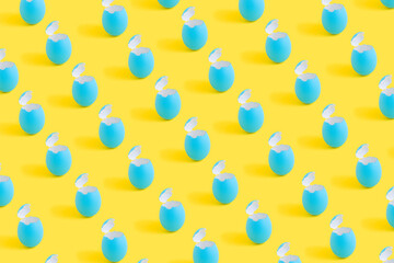Creative minimal Easter concept with blue eggshells on yellow background