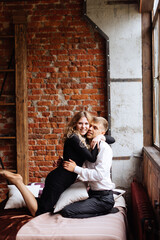 Obraz premium A young man and a woman embrace in a loft-style interior