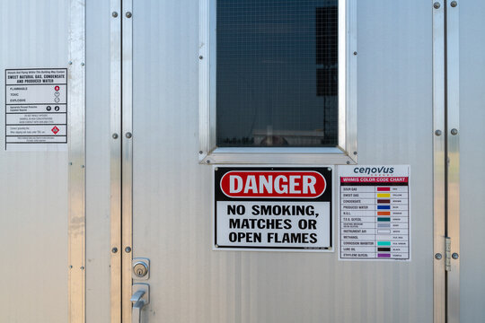 A color code chart for industrial pipelines posted on a metal utility building near Elmworth, Alberta, Canada - July 25, 2018