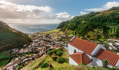 Small village Faial da Terra between rolling hills in warm afternoon light on Sao Miguel Island in...