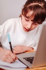 Niña haciendo deberes con un ordenador portátil