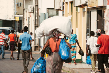 Inhambane, Mozambique, September, 19th 2018: African woman carrying large packages on a street full...