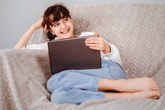 Ni&ntilde;a viendo la tablet y escuchando m&uacute;sica 
