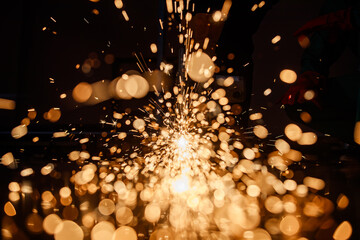 spark in a dark background from a hot red metal cut by a steel cutting machine in a factory. Nice...