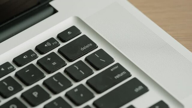 CRASH ZOOM IN Caucasian male furiously pushing delete button on a laptop keyboard