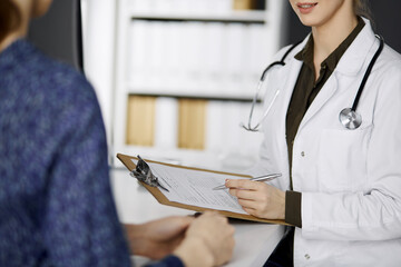 Doctor and patient discussing current health examination while sitting in clinic. Perfect medical...