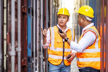 Professional of two engineer or supervisor checking and control loading Containers box from Cargo at harbor. Transportation and logistic concept