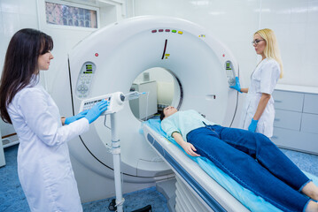 Radiologist with a female patient in the room of computed tomography