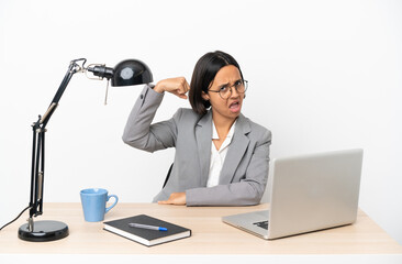 Young business mixed race woman working at office doing strong gesture