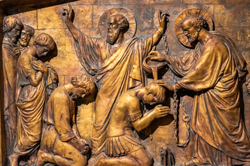 Close-up on religious catholic scene carved on bronze