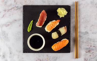 Japanese sushi food. Nigiri with tuna, salmon, shrimp served with soy sauce, ginger, and wasabi.