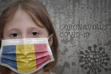 Little girl in medical mask with flag of chad stands near the old vintage wall with text...