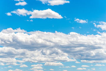 White cumulus clouds against a deep blue sky