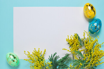 A blank sheet of paper copies the space with the sprigs of mimosa Easter eggs. Brand minimalism. A postcard for Easter.