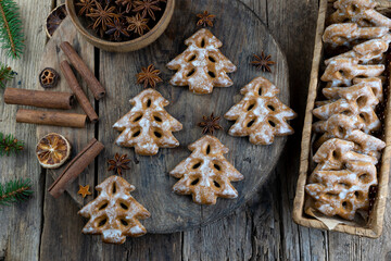 Obraz na płótnie Canvas Christmas tree cookies on wooden background. New Year's food. Anise star. Festive baked goods. Gingerbread on the table.Icing sugar sweetness taste season