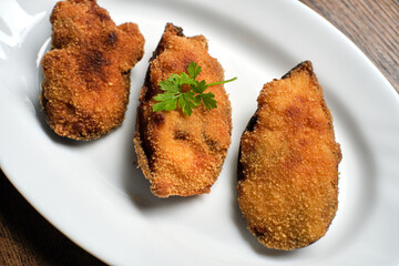 Battered fried mussels on a white plate