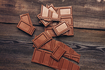 bar of chocolate broken into cubes on a wooden table