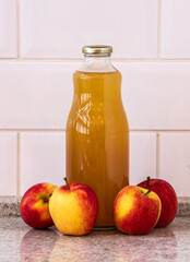 Natural juice from organic apples in bottle and apples on the side