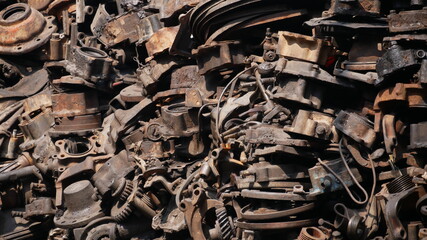 Pile of old machine parts in second hand machinery shop, background of damage and rusty old car machine	