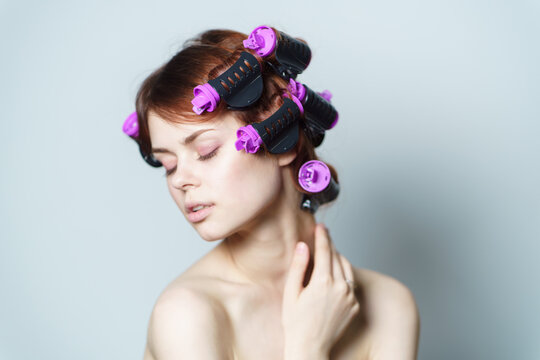 pretty woman with curlers on her head hairstyle naked shoulders makeup