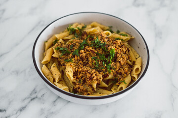 vegan penne pasta with plant-based meat and lemon sauce, healthy plant-based food