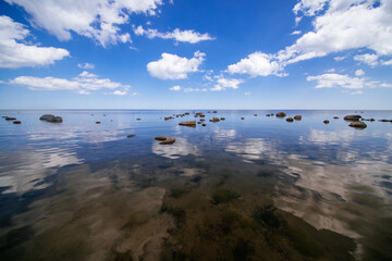 Scenic landscape of clouds reflecting over the rocky sea