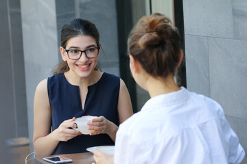 Woman with friend relax talking and drink coffee or tea