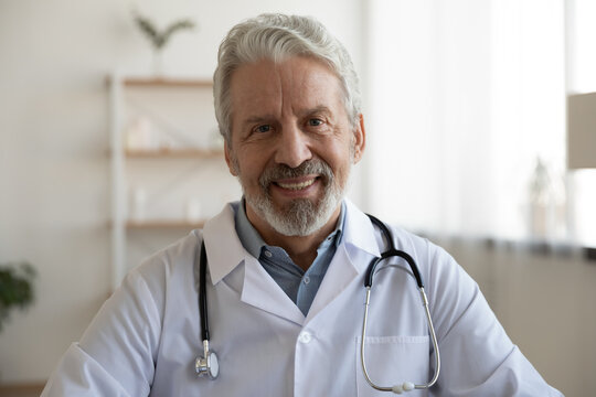 Profile Picture Of Smiling Mature Caucasian Male Doctor In White Medical Uniform In Private Hospital. Portrait Of Happy Senior Man GP Talk On Video Call, Speak In Webcam Conference With Patient.