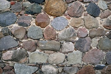 The wall of the building is made of chipped stone on a mortar. Beautiful texture	