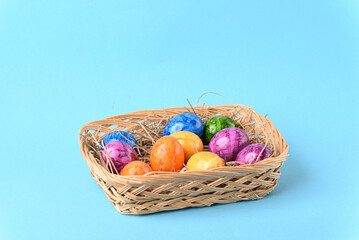 Colorful easter eggs in the basket on the blue background.