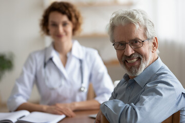 Portrait of smiling mature male patient feel excited about good quality service in private...