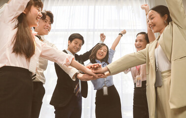 Fototapeta na wymiar Young business people stack hands with coworker team while group teamwork meeting in conference room