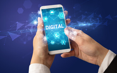 Female hand holding smartphone with DIGITAL inscription, modern technology concept