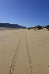 sand dunes with tyre tracks