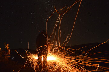 man against sparks from the fire