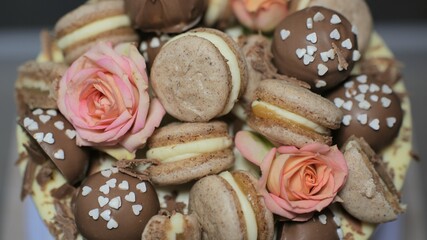 Cookies with roses lie on a cake with white icing.