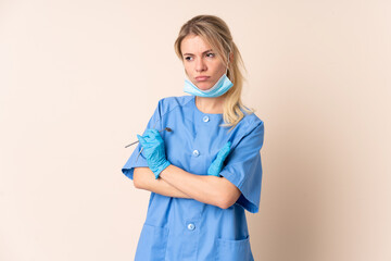 Dentist woman holding tools over isolated background thinking an idea