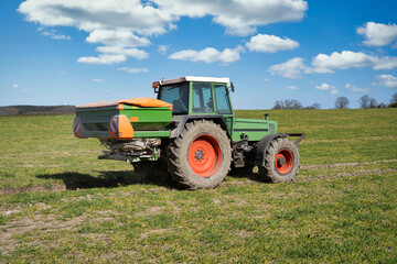 Düngerverordnung - Landwirt verteilt mit dem Düngerstreuer Mineraldünger auf einem  Feld, Symbolfoto.