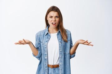 Confused and angry woman complaining at something, staring annoyed and bothered, having an...