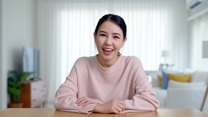 Portrait confident asia creative female vlogger make live talk video conference call, chat online on computer and sitting on table at home, Webcam view, video chat camera and Self isolation concept.