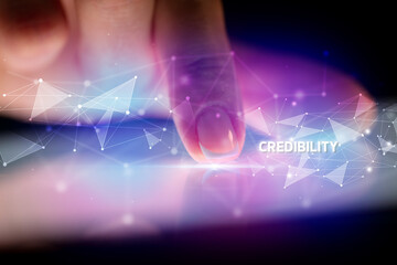 Finger touching tablet with CREDIBILITY inscription, business concept