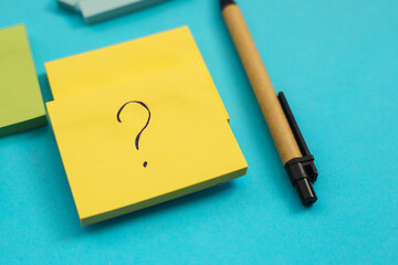 Stickers of different sizes and colors are placed on a blue background. There's a pen next to it.