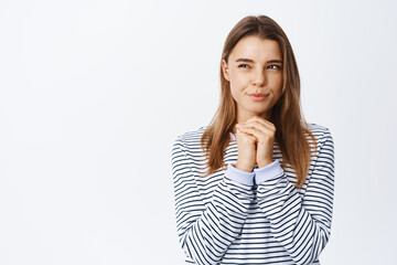 Portrait of thoughtful young woman with blond hair, squinting pensive, having interesting idea,...