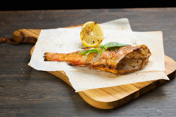 whole baked fish in foil with lemon. fried bass