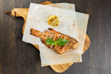 whole baked fish in foil with lemon. fried bass