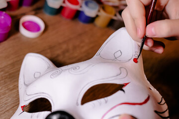 A cat mask design making by teenage girl. Drawing, creativity, hobby, diy, painting, development, education concept. Do it yourself step by step process.