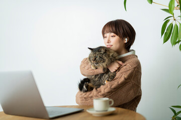 猫に作業を邪魔される女性