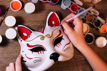 A fox mask design making by teenage girl. Drawing, creativity, hobby, diy, painting, development, education concept. Do it yourself step by step process.