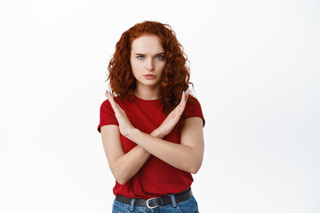 Serious ginger woman making cross stop gesture, say no, block and prohibit bad offer, standing...
