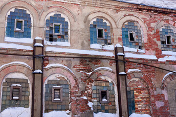 An abandoned, crumbling old factory building. Winter landscape.